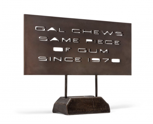 Ed Ruscha Gal Chews Same Piece of Gum bronze sculpture with stenciled text and dark patina on rectangular base.