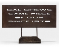 Ed Ruscha Gal Chews Same Piece of Gum bronze sculpture with stenciled text and dark patina on rectangular base.