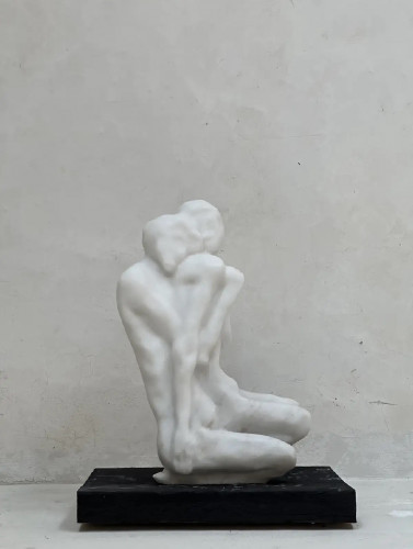 Eva Claessens marble sculpture Seeking the Silence, 2024, featuring two abstract, intertwined faceless figures in a contemplative seated pose.