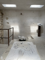 Eva Claessens Dao 2025 marble sculpture of elongated reclining form on dark base against textured wall  