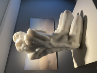 Eva Claessens marble sculpture Seeking the Silence, 2024, featuring two abstract, intertwined faceless figures in a contemplative seated pose.