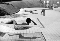 Martine Franck, Swimming Pool (by Alain Capeilleres), black-and-white photo of modernist poolside scene with geometric patterns and relaxed figures.