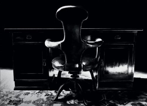 Robert Longo Freud’s Desk and Chair pigment print showing dramatic black chair and desk in dark study with patterned rug.  