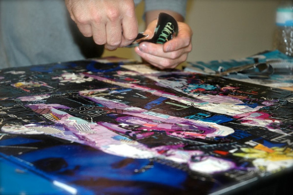 Creation of a collage by Derek Gores, during one of his exhibitions/shows, 2016 / © Emma.att, CC BY-SA 4.0, via Wikimedia Commons